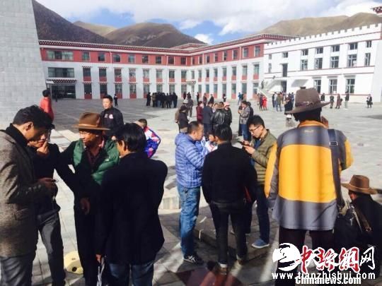 图为地震发生后，杂多县政府工作人员站在办公楼外躲避余震 尕玛求加 摄