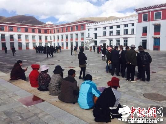 图为地震发生后，杂多县政府工作人员站在办公楼外躲避余震 尕玛求加 摄