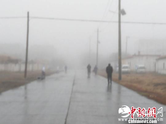 行人在结冰的路面上小心行走。 张雯程 摄