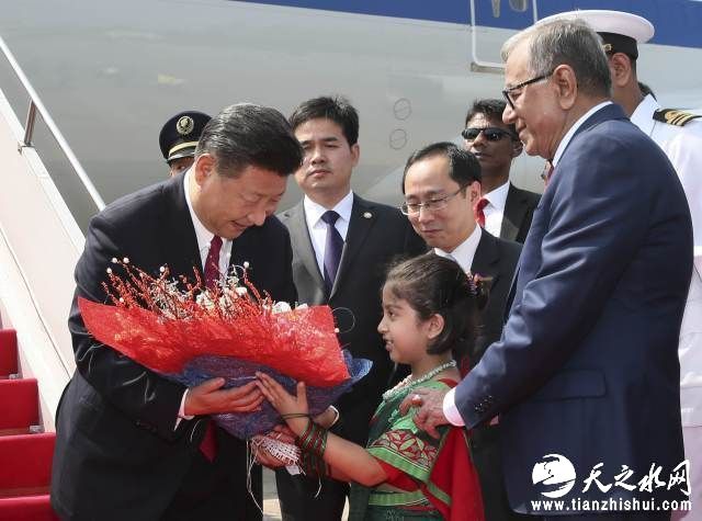 图为10月14日，国家主席习近平抵达达卡，开始对孟加拉人民共和国进行国事访问。这是习近平接受孟加拉国儿童献花。（新华社记者兰红光摄）