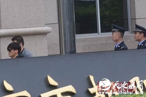 王宝强在工作人员和警察的护送下进入法院。