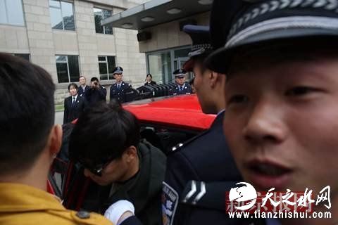 王宝强在工作人员和警察的护送下进入法院。