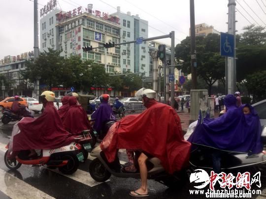 广西沿海居民穿雨衣出行。 翟李强 摄