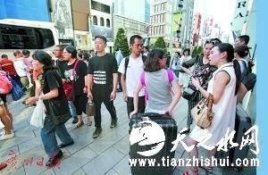 2016年10月16日，中国游客在日本东京街头驻足交谈。