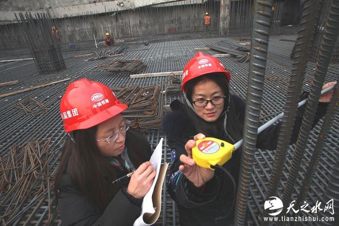 nEO_IMG_4、中国铁建十八局集团五公司欣嘉园项目总工梁素琴 （左）、技术员赵兰杰在现场抽查钢筋绑扎情况（伍振 摄）