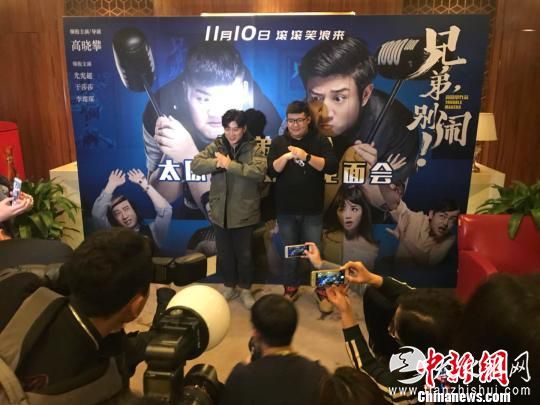 高晓攀和尤宪超在结束采访后双手抱拳拍照合影。　胡健 摄