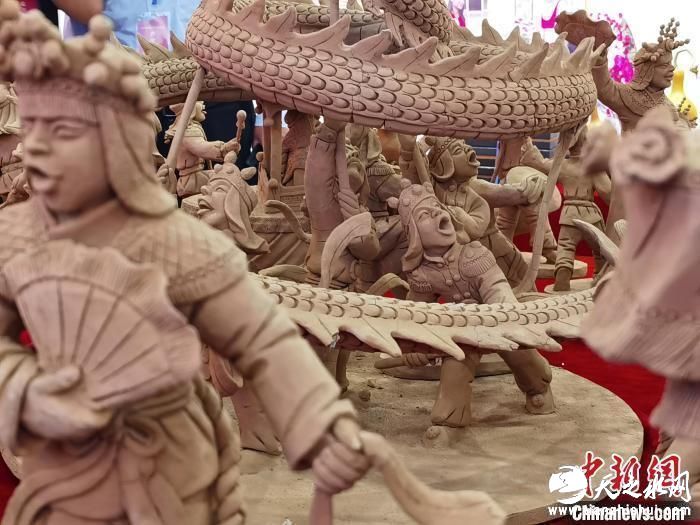 图为甘肃省临夏州非遗传承人常天平制作的农民舞狮舞龙舞狮闹社火泥塑群雕进行展出。　闫姣 摄