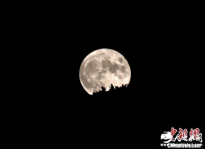 9月10日晚，游客在敦煌市鸣沙山月牙泉景区赏月。　张晓亮 摄