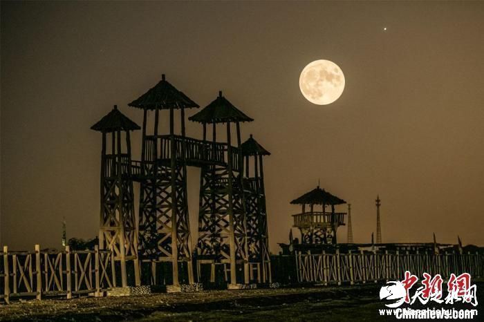 9月10日晚，一轮圆月升起在敦煌阳关景区上空。(双重曝光) 王斌银 摄