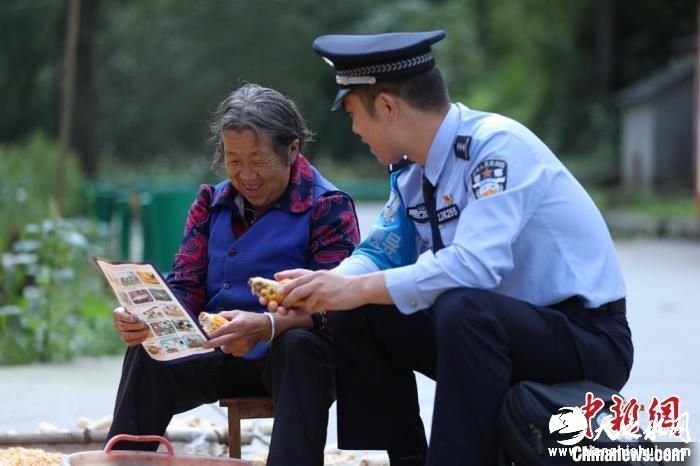 图为民警背警务小包给民众宣讲政策。(资料图) 甘肃省公安厅供图